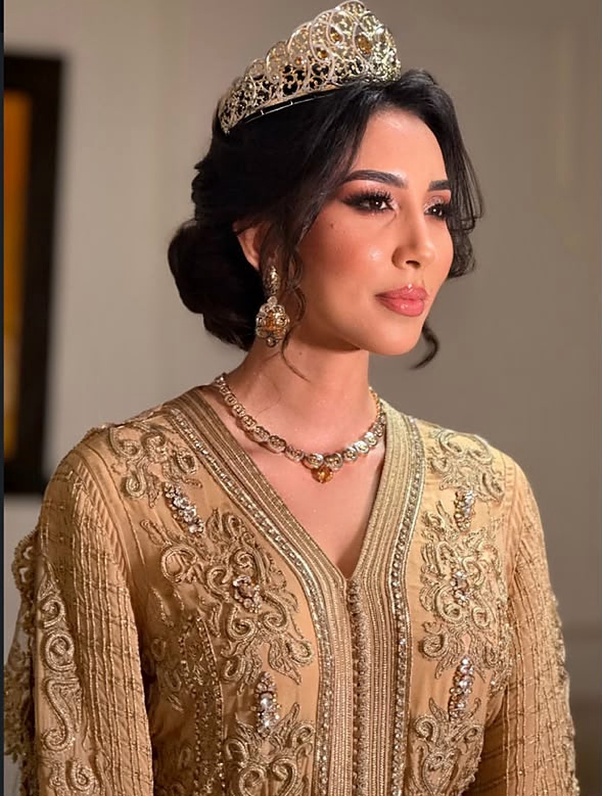 Mariée coiffée et maquillée avec couronne dorée et caftan beige